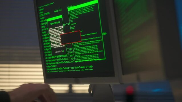 Hacker is typing on a computer keyboard. A green line of program codes appears on the screen and a warning access is denied. A black flash drive with a red flashing light in the USB port.