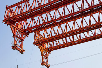 crane part, truss, detail of red, black steel truss tower crane under blue sky. construction and...