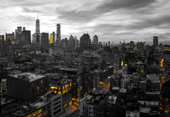 Black and white New York City skyline buildings at night with yellow lights of the downtown...