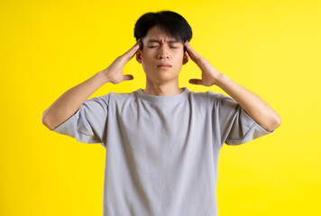 image of handsome young man posing on a yellow background