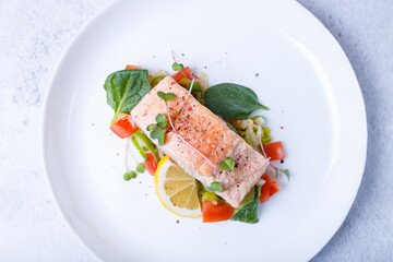 Trout (salmon) with vegetables, lemon and microgreens, cooked by the confit method. Traditional French dish. Step by step. Close-up.