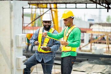 Male engineers are inspecting and controlling the work of the employees and the quality of the manufactured products to meet the standards In industrial factories producing precast prefabricated walls