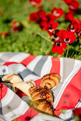 Picnic with fresh bakery on the field of Anemones
