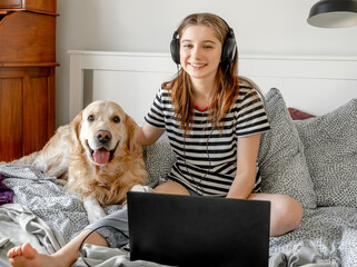 Girl with golden retriever dog in bed