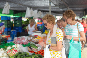 An adult female couple shopping at a fruit market