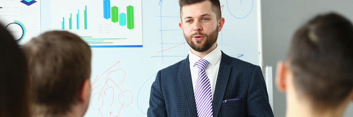 Male business coach speaker in suit makes presentation