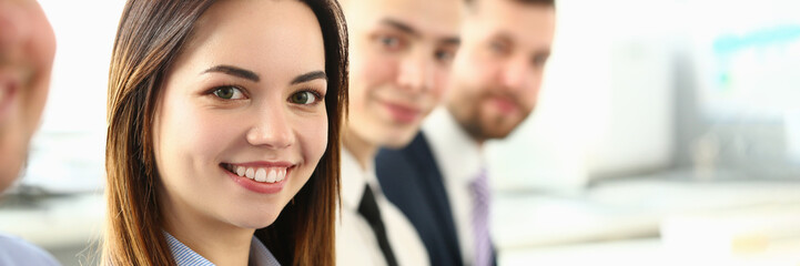 Portrait of pretty young business woman smiling at meeting with colleagues