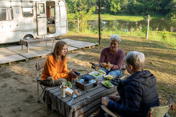 Happy family eating breakfast at tent camping.