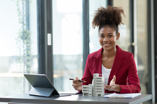 African american female architect or designer, businessman, and engineer working in the office on building projects Residential condos to buy and rent real estate projects.