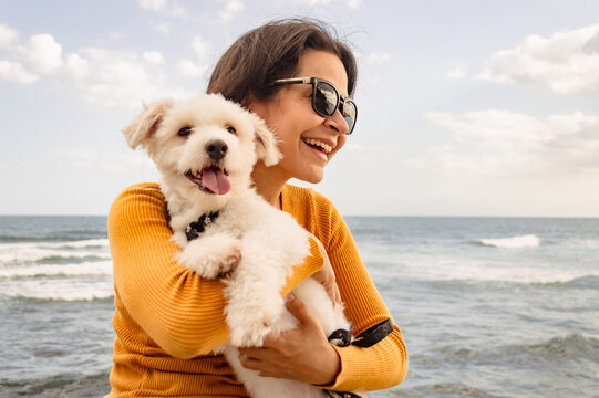 Young woman enjoys a sunny day on the boardwalk with her dog, family outdoor lifestyle dog. Close up