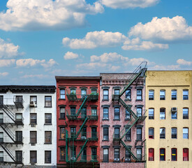 Block of colorful old apartment buildings with empty blue sky background in Manhattan, New York City - 573607743