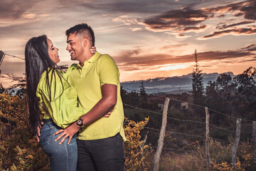 Pareja joven en un atardecer mirándose con mucho amor