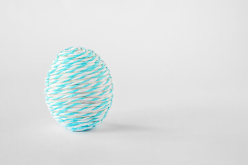 Easter minimal composition with egg on a textured light background. Copy space.
