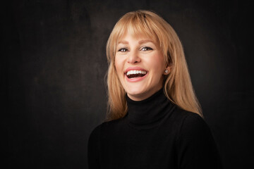 Heashot of an attractive middle age woman against dark background