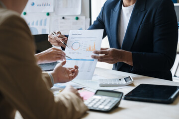 A group of Asian businessmen meet, plan and discuss data analysis, charts, graphs, financial calculations, income, taxes and business performance. marketing accounting concept.