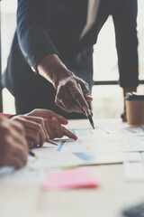 A group of Asian businessmen are meeting, planning and discussing data analysis, growth charts, graphs, financial calculations, marketing, revenue management. Various taxes within the joint office.