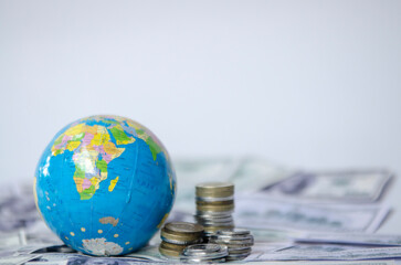 globe on dollar banknote and coins, saving and managing money, transport, transportation insurance business technology, economic crisis risk and problem concept. selective focus