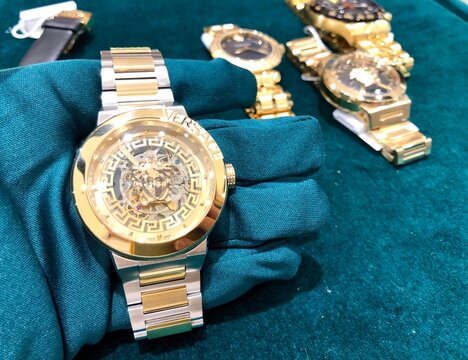 Alicante, Spain - February, 2023: Versace automatic gold color watch on green background . High quality photo