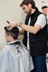 Barber shaving caucasian man in barber shop.