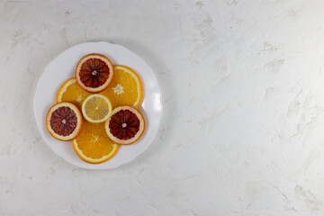 There are lemons, tangerines in the plate. On a white background. Copy space.