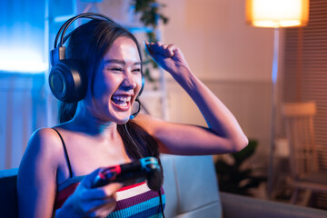 Young asian woman is using virtual reality headset. Neon light studio portrait. Concept of virtual reality, simulation, gaming and future technology.Asian woman play game in living room.
