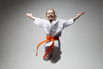 Child girl jump in kimono at karate lesson. © Andrii Zastrozhnov