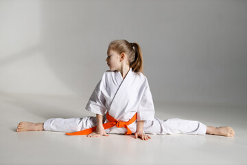 Little girl kimono fighter on a twine on a white background.
