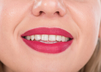 Obraz premium Woman Face With Pretty Smile and White Teeth. Studio Photo Shoot. Use Bright Red Lipstick.