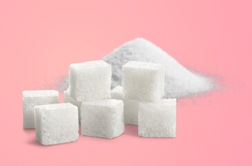 Pile of sugar and cubes on color background