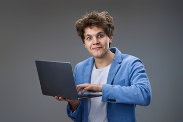 caucasian man with laptop on gray background