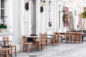 Beautiful bright summer cafe with wooden chairs on the street of Cyprus. Selective focus