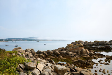 Fototapeta na wymiar Galician beach with rocks and blue sky. Nature background.