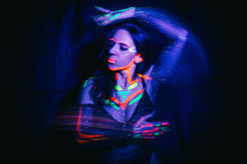 Portrait of a beautiful woman with blue sequins on her face. Girl with artistic make-up in Light...