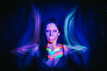 Model woman in neon light, beautiful model girl with fluorescent makeup, art design of disco dancer...