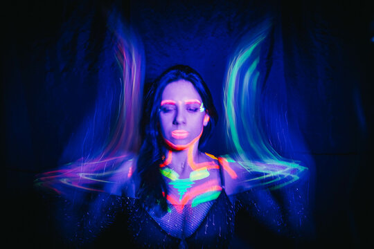 Model woman in neon light, beautiful model girl with fluorescent makeup, art design of disco dancer dancing in uv light, colorful makeup. Nightclub, Party. 4K video.