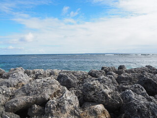 stone wall at beach in the Caribbean - blue ocean water in the evening