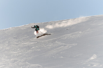 view on freerider on snowboard speedly descends an off-piste on snow of mountain hill
