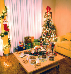 Living room of house at Christmas with table with food and champagne candles and chairs background gifts and tree, Christmas painted wall and wooden floor