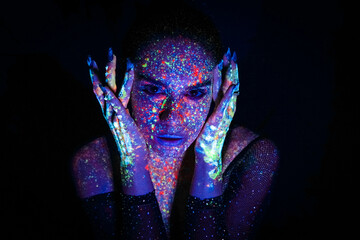 Portrait of a beautiful woman with blue sequins on her face. Girl with artistic make-up in Light color. Fashion model with colorful makeup.