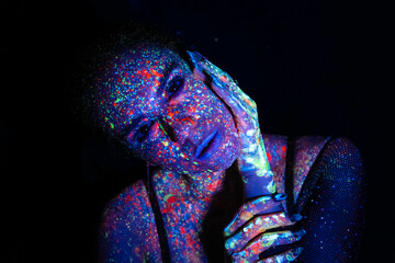 Fashion model woman in neon light, portrait of a beautiful model with fluorescent makeup, artistic...