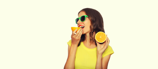 Summer portrait of happy smiling young woman with slices of fresh orange fruits wearing sunglasses on white background