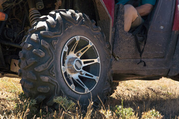Fototapeta na wymiar close up of a wheel tire with on a utv buggy driven by a senior adult