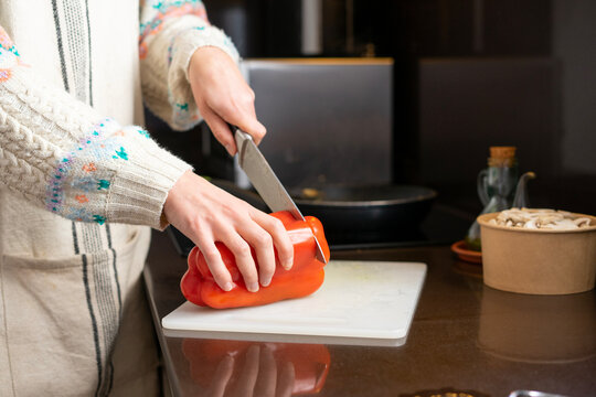 Girl Cooking. Girl Cutting Red Pepper