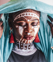 Woman from Africa wearing headdress and tribal painting
