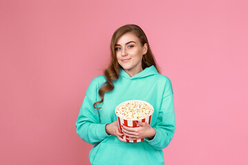 woman in sweatshirt watching movie film, eating popcorn