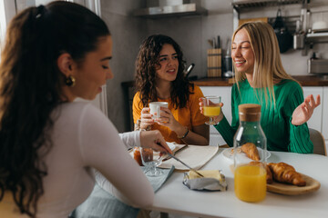 Three female friends are talking over breakfast