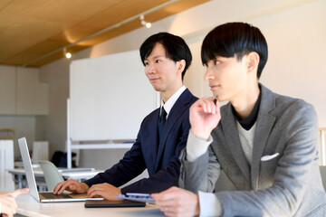 並んで座るビジネスマンの男性達