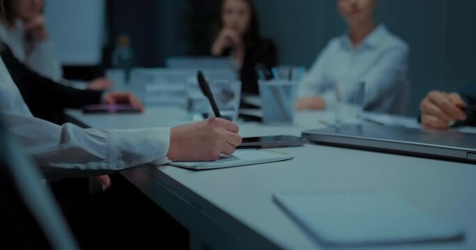 office workers boring in meeting, woman writing and drawing in notebook, closeup view, 4K, Prores