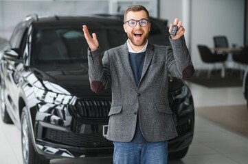 Young man with the keys at the car