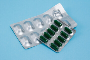 Capsules in blisters on a blue paper background